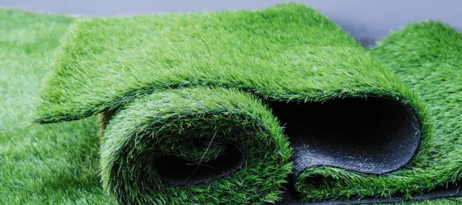 Rollos de pasto sintético de color verde vibrante mostrando diferentes texturas y densidades para jardín o terraza